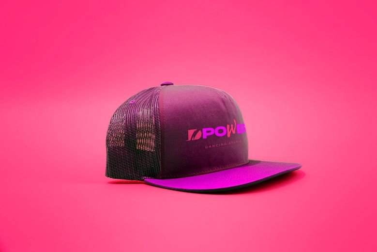 Gorra morada de DPower sobre fondo rosa